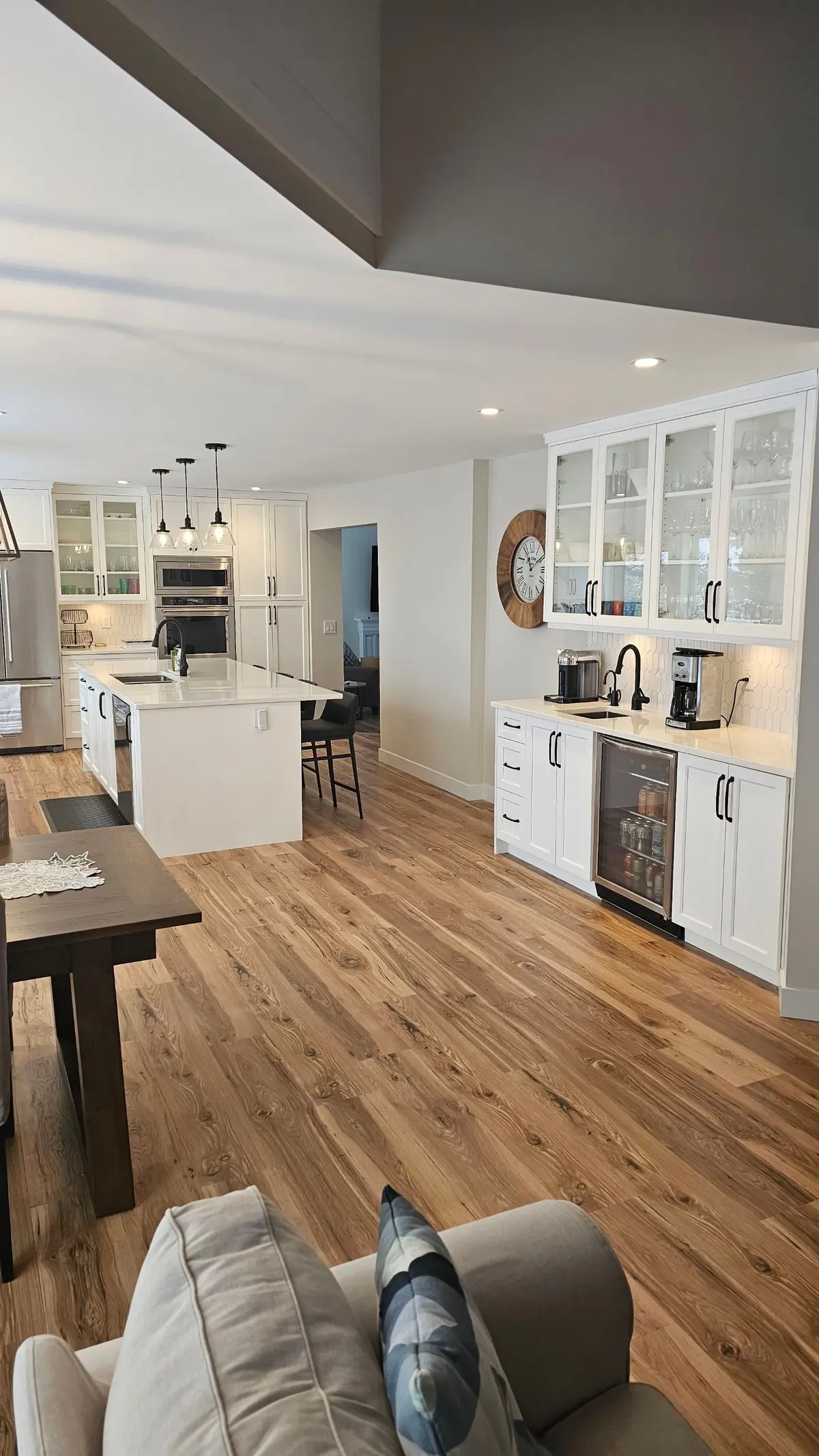 A finished kitchen with pendant lights and pot lights